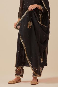 Black anarkali with sequin hand embroidery and gathered detail. Paired with embroidered pant and embroidered dupatta.
Components: 3
Pattern: Embroidered
Type Of Work: Sequin
Neckline: Scoop
Sleeve Type: Sheer
Fabric: Anarkali and Pant: Chanderi, Dupatta: Tissue Organza
Color: Black
Other Details: 
Weight: 2 kgs
Length:
Anarkali: 47 inches
Pant: 37 inches
Closure:
Pant: Elasticated back
Model is wearing size S
Occasion: Sangeet - Aza Fashions Chinon Churidar With Sheer Dupatta For Diwali, Black Anarkali Palazzo Set With Mirror Work, Black Salwar Kameez With Dupatta In Chinon, Black Chinon Salwar Kameez With Dupatta, Anarkali Palazzo Set With Dupatta In Chinon, Black Palazzo Set With Gota Work For Eid, Festive Kundan Churidar With Sheer Dupatta, Black Anarkali Dupatta In Chinon, Black Anarkali Style Dupatta In Chinon