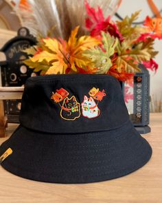 Lucky Cats have fun! Features Hat circumference ~23 inches Adjustable straps inside Mesh lining Adjustable Black Hat With Cat Design, Long Sleeve Outerwear, Year Of The Rabbit, Banner Printing, Lucky Cat, Bucket Hats, Printed Bags, Embroidered Design, Printed Tote Bags