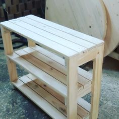 a wooden shelf sitting on top of a floor next to a large piece of wood