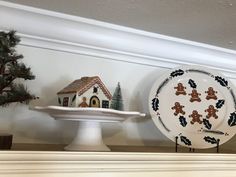 two plates with gingerbread cookies on them are sitting on a mantel