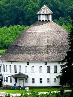 a large white building surrounded by lush green trees