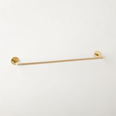 a gold colored towel bar on a white wall