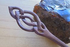 a piece of wood sitting on top of a wooden table next to a metal object