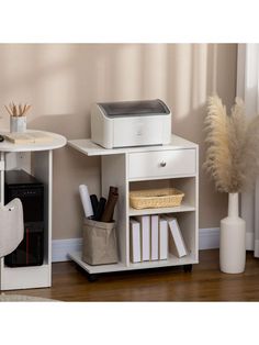 a white shelf with some books and other items on it next to a printer machine