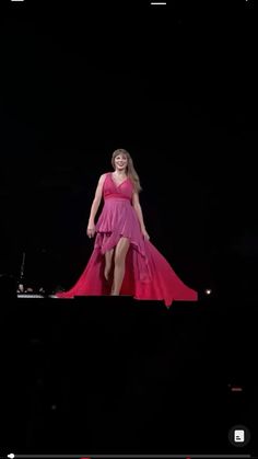 a woman in a pink dress on stage