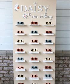 a display with many pairs of sunglasses on it's sides and the words daisy me rolling above them