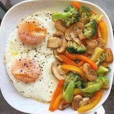 a white plate topped with mushrooms, broccoli and eggs