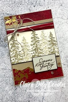 a handmade christmas card with pine trees on it and a ribbon tied around the edge