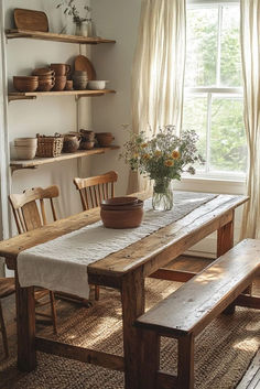 a wooden table sitting in front of a window next to a vase filled with flowers