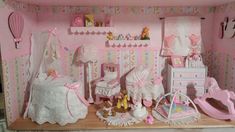 a doll's bedroom with pink furniture and accessories on the floor, including a baby crib