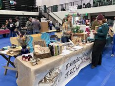 two women standing at a table selling items