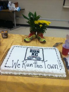 a cake that is sitting on a table with flowers in the middle and we run the town written on it