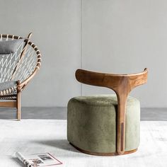 a chair and ottoman in a room with a magazine laying on the floor next to it