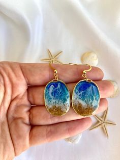 🌊 How will you feel wearing these earrings? Are you an ocean and beach lover like us? If you are here, we are sure you are! These beachy earrings are lightweight and super summery vibes! While you carry the sand and the waves in these blue earrings, you will feel calm and relaxed with this piece of jewelry. 🌊 What materials are they made of? We handmade these ocean earrings with real sand from a Portuguese beach, and with a wave effect, for you to carry the ocean everywhere you go! Our ocean j Beachy Earrings, Wave Earrings, Surfer Jewelry, Ocean Earrings, Surfer Style, Earrings Summer, Ocean Jewelry, Jewelry Blue, Ocean Lover