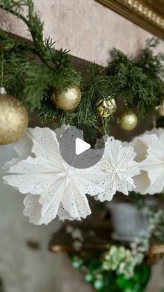 christmas decorations hanging from the ceiling in front of a mirror with gold ornaments on it