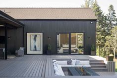 an outdoor living area with couches, tables and stairs leading up to the front door