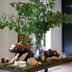 a table topped with lots of food and greenery