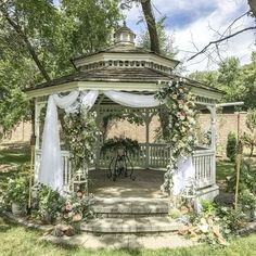 a gazebo with flowers and greenery around it