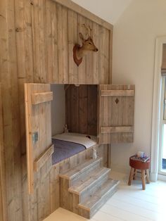 there is a bunk bed in the corner of this room with wooden walls and stairs