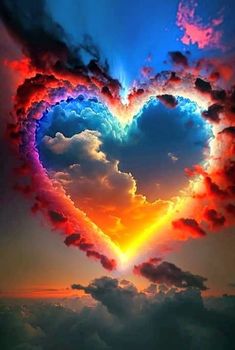 a heart shaped cloud in the sky with colorful clouds and sun rays coming out from behind it