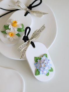 two tags with flowers on them sitting on a plate