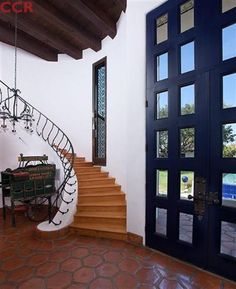 a staircase leading up to a pool in a house with glass doors and brick flooring