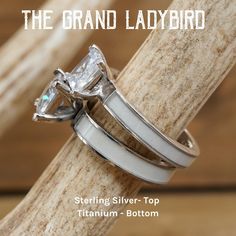 two wedding rings sitting on top of a piece of wood with the words, the grand ladybird