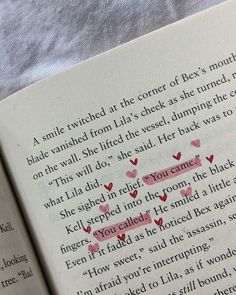 an open book with some writing on the page and two hearts drawn in red ink