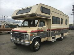 an rv parked in a parking lot next to other vehicles