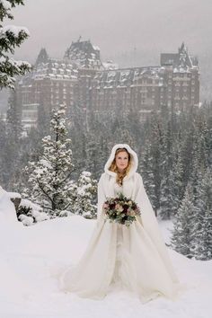 a woman in a white wedding dress standing on top of snow covered ground