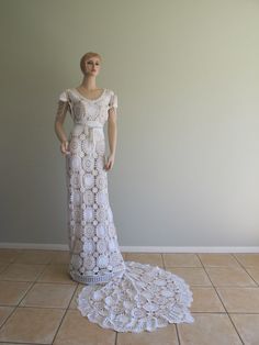 a mannequin dressed in a white dress on a tile floor next to a wall