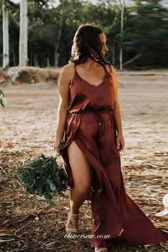 a woman in a red dress is standing outside