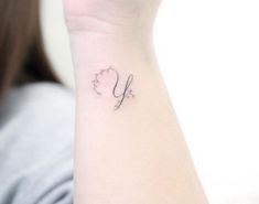 a woman's wrist with a small tattoo on the left side of her arm