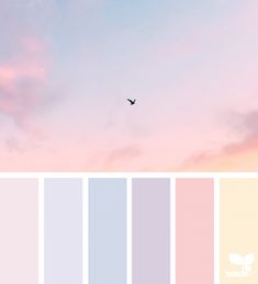 there is a bird flying in the sky with colors that are pink, blue and yellow