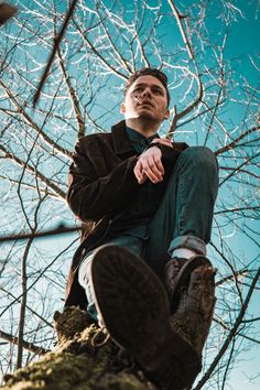 a man sitting on top of a tree branch