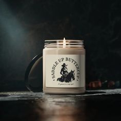 a candle that is sitting on top of a table with a horse and rider sticker on it