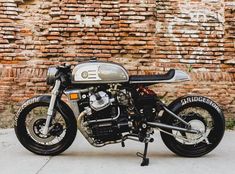 a motorcycle parked in front of a brick wall