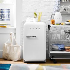 a white refrigerator freezer sitting on top of a wooden floor next to a table