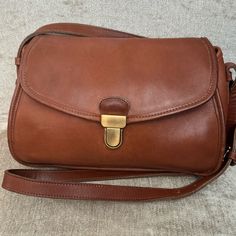 Vintage Coach Gilford Bag - British Tan In Color. Excellent Condition. Leather Is Soft, Conditioned And Free From Tears, Holes. Interior Flap Has A Few Pin Marks, Please See Picture. Overall, This Bag Is Beautiful For Its Age. Brass Touchlock Closure Slip Pockets Exterior Backside, Interior Zipper Pocket And Pocket Under Flap In Front Of Bag. 10.25”W X 7”H X 4”D Strap Drop 48” Bags Vintage, Vintage Coach, Zipper Pocket, Coaching, Overalls, Bag Lady, Brass, Exterior, Shoulder Bag