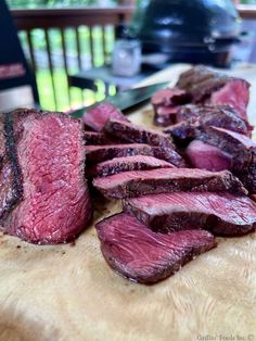 sliced up steak sitting on top of a wooden cutting board