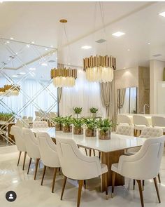 an elegant dining room with white chairs and gold chandelier hanging from the ceiling