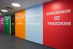 an empty hallway with colorful walls and writing on the wall that says education, freedom