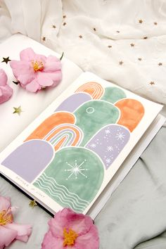 an open book on a bed with pink flowers