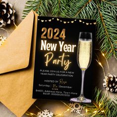 a new year's party card with champagne and pine cones on the table next to it