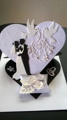 a white and black wedding card with a bride and groom in the heart on it