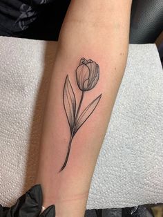 a black and white photo of a flower on the left arm, with a single tulip in the center