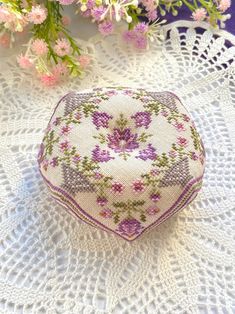 a white doily with pink and purple flowers on it