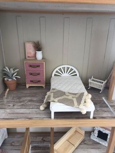 a dollhouse bedroom with a bed and dresser