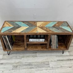 a wooden entertainment center with cd's on wheels