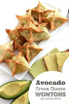 avocado cream cheese wontons on a plate next to sliced avocados